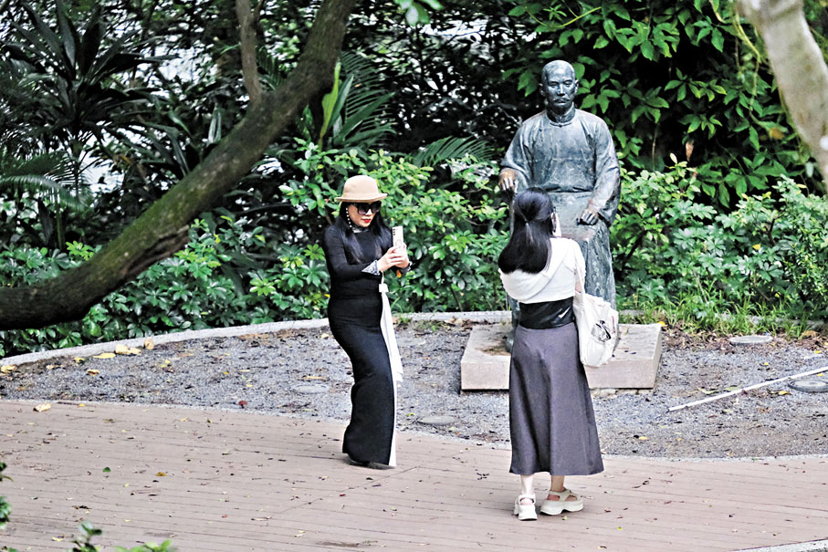 ◆一遊客拍下港大孫中山銅像，她的同伴也把這情境拍下來。香港文匯報記者涂穴 攝