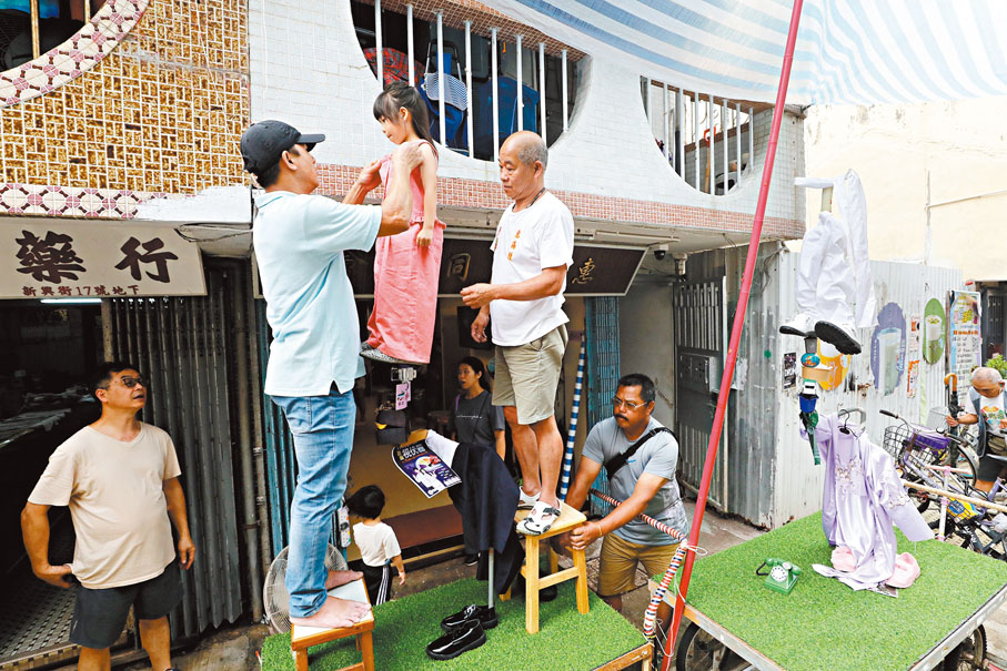 ◆「色芯」由家長帶到街坊會後，量高度然後放上飄色架試位。 香港文匯報記者郭木又  攝