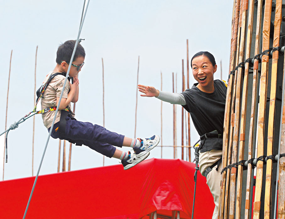 ◆韓女士帶兒子爬包山架。香港文匯報記者郭木又 攝