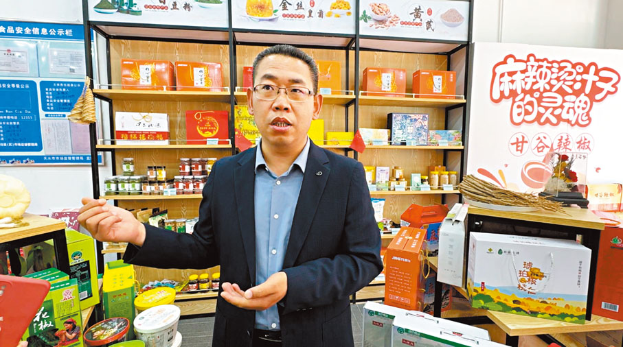 ◆王煥文向記者介紹甘谷辣椒產品。