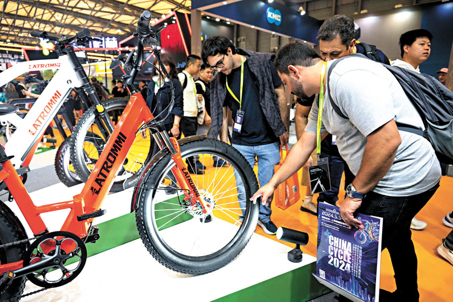 ◆5月5日，中國國際自行車展覽會上，巴西展商在觀看展出的自行車。 網上圖片