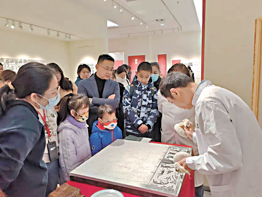 ◆工作人員現場展示傳拓技藝，吸引觀眾圍觀欣賞。   殷江宏  攝