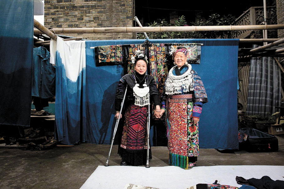 ◆張艷梅（左）和母親在苗繡作品前合照。香港文匯報北京傳真
