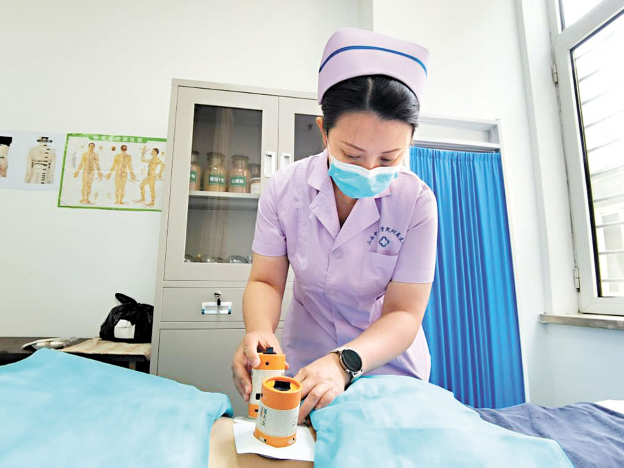 ◆在中國中醫科學院西苑醫院山西醫院中醫護理門診，譚娟為患者做艾灸護理。 網上圖片