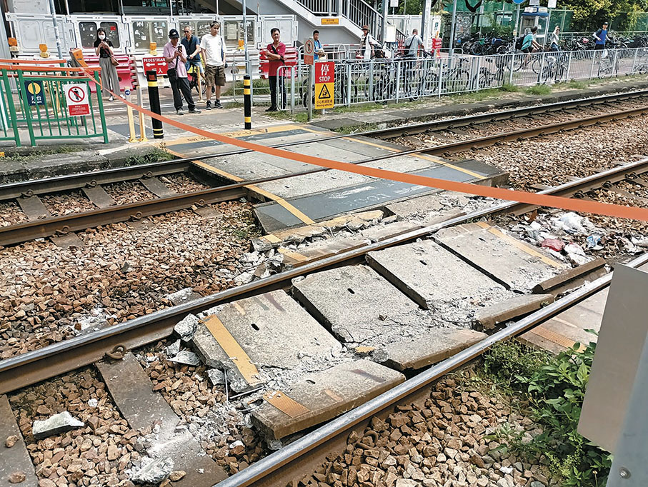 ◆出軌輕鐵列車駛過的路軌出現損毀，行人過路處有石屎板損毀碎成多塊。 香港文匯報記者鄺福強  攝