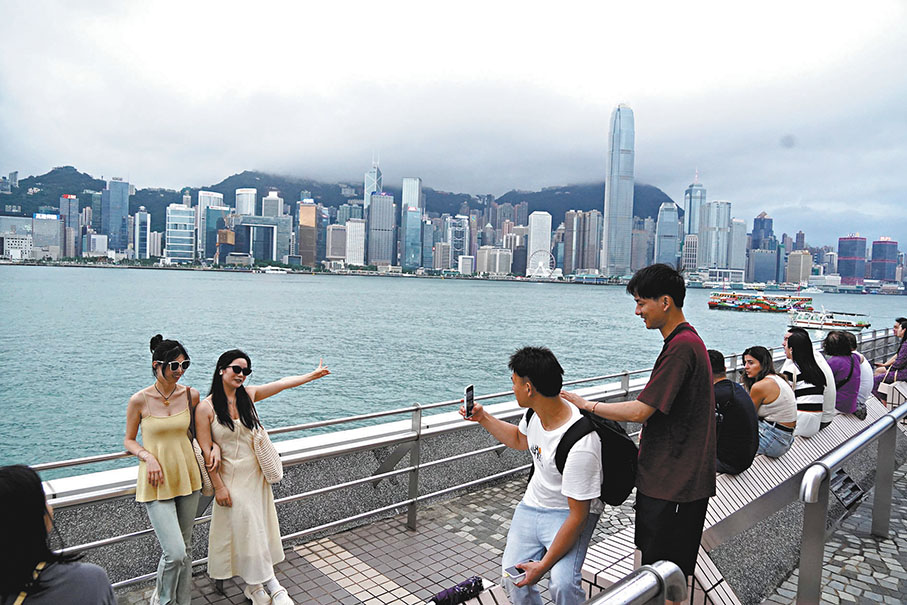 ◆香港天文台昨日下午改發三號強風信號，預料「馬力斯」向北移動，但強風似乎未影響遊客在維港「打卡」興致。 香港文匯報記者曾興偉  攝