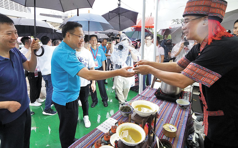 ◆何靖在廣西攤位品嘗油茶。香港文匯報記者曾興偉  攝