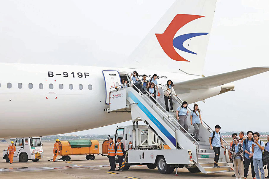 ◆乘坐C919飛抵上海的港生走出艙門。 香港文匯報記者夏微  攝