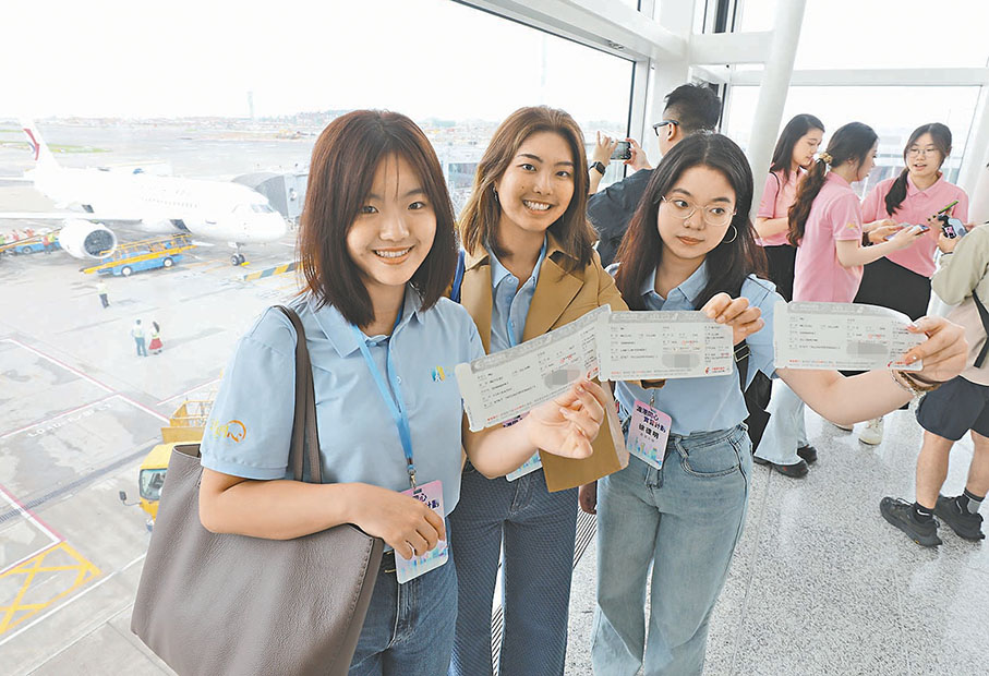 ◆學生在登機前手持機票合影。 香港文匯報記者黃艾力 攝