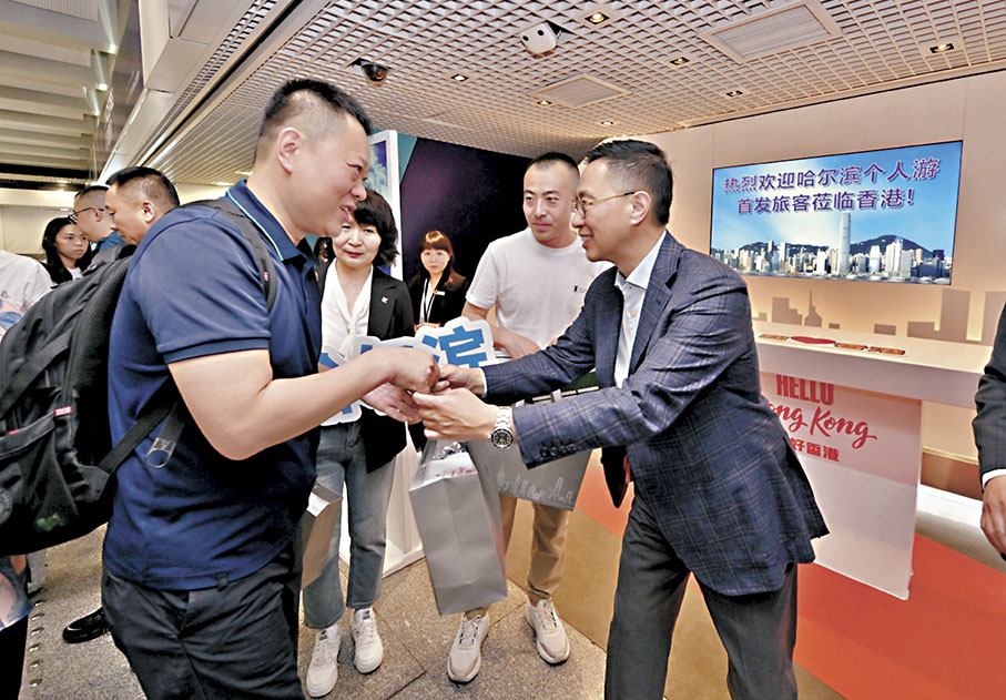 ◆楊潤雄（右一）迎接來自內地城市的旅遊業界代表並贈送紀念品，展現香港對他們的熱烈歡迎。