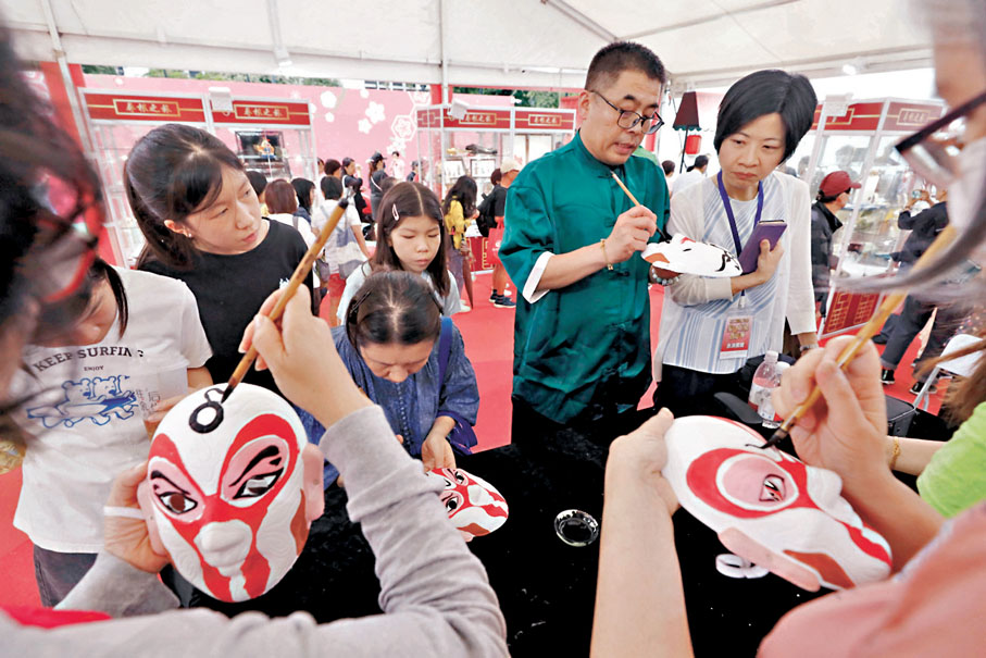 ◆何女士一家第一次體驗畫臉譜的過程。香港文匯報記者北山彥  攝