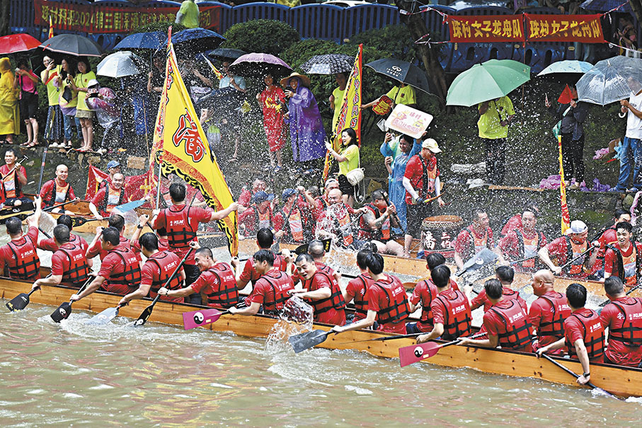 ◆6月3日，在廣州深涌河道內，來自深涌兩岸村落的10條傳統龍舟在雨中展開角逐。圖為賽後潑水慶祝。 中新社