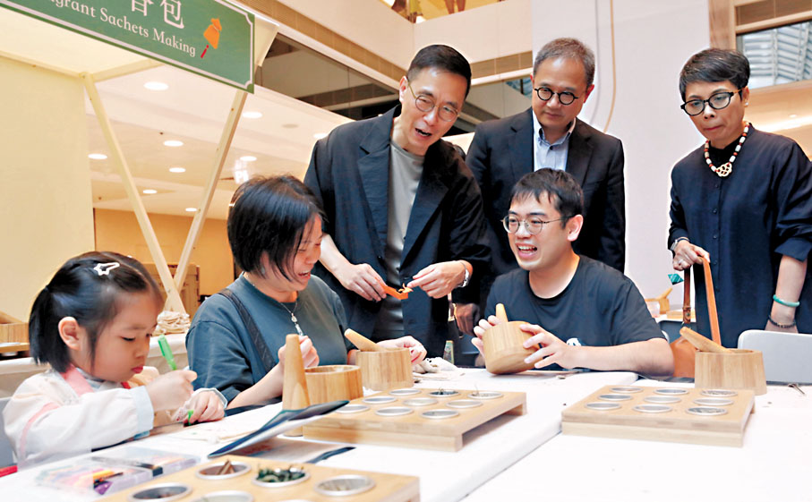 ◆親子一起學製香包，楊潤雄與他們交流。香港文匯報記者郭木又 攝