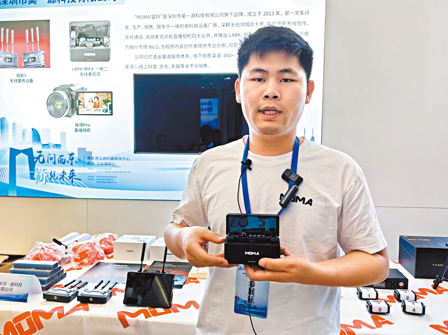 ◆深圳市昊一源科技有限公司銷售經理柯龍展示公司產品。 香港文匯報記者郭若溪 攝