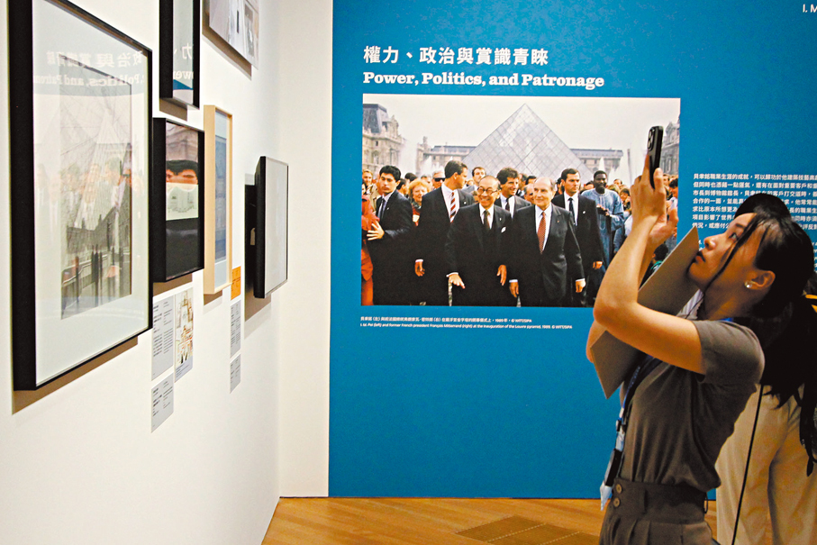 ◆記者聚精會神拍下貝聿銘的作品向讀者介紹。牆上的照片記錄了羅浮宮金字塔1989年的開幕禮。  香港文匯報記者黃艾力 攝