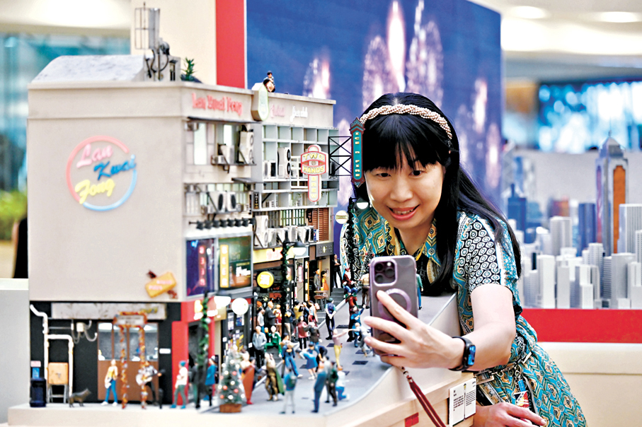 ◆現場人士近距離與微縮模型作品《蘭桂坊》合影。 中新社