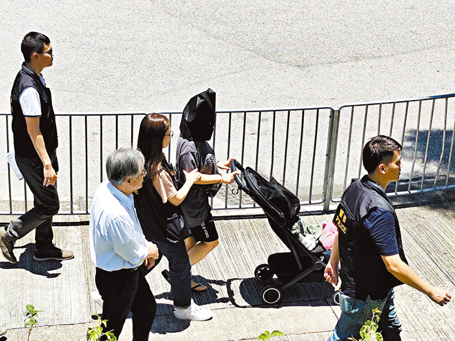 ◆女疑犯（黑布蒙頭）推着載有人形公仔的嬰兒車，模擬綁架男童逃走路線。 香港文匯報記者鄺福強  攝