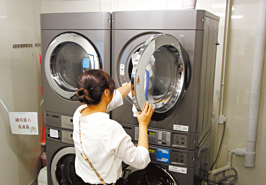 ◆使用者示範使用洗衣設備。香港文匯報 記者黃艾力  攝