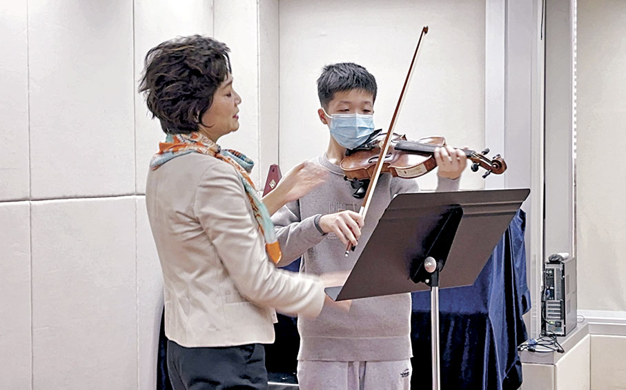 ◆姚珏指導靖甫拉琴的指法，而靖甫亦透過不斷的訓練增加了自信心。 香港弦樂團供圖