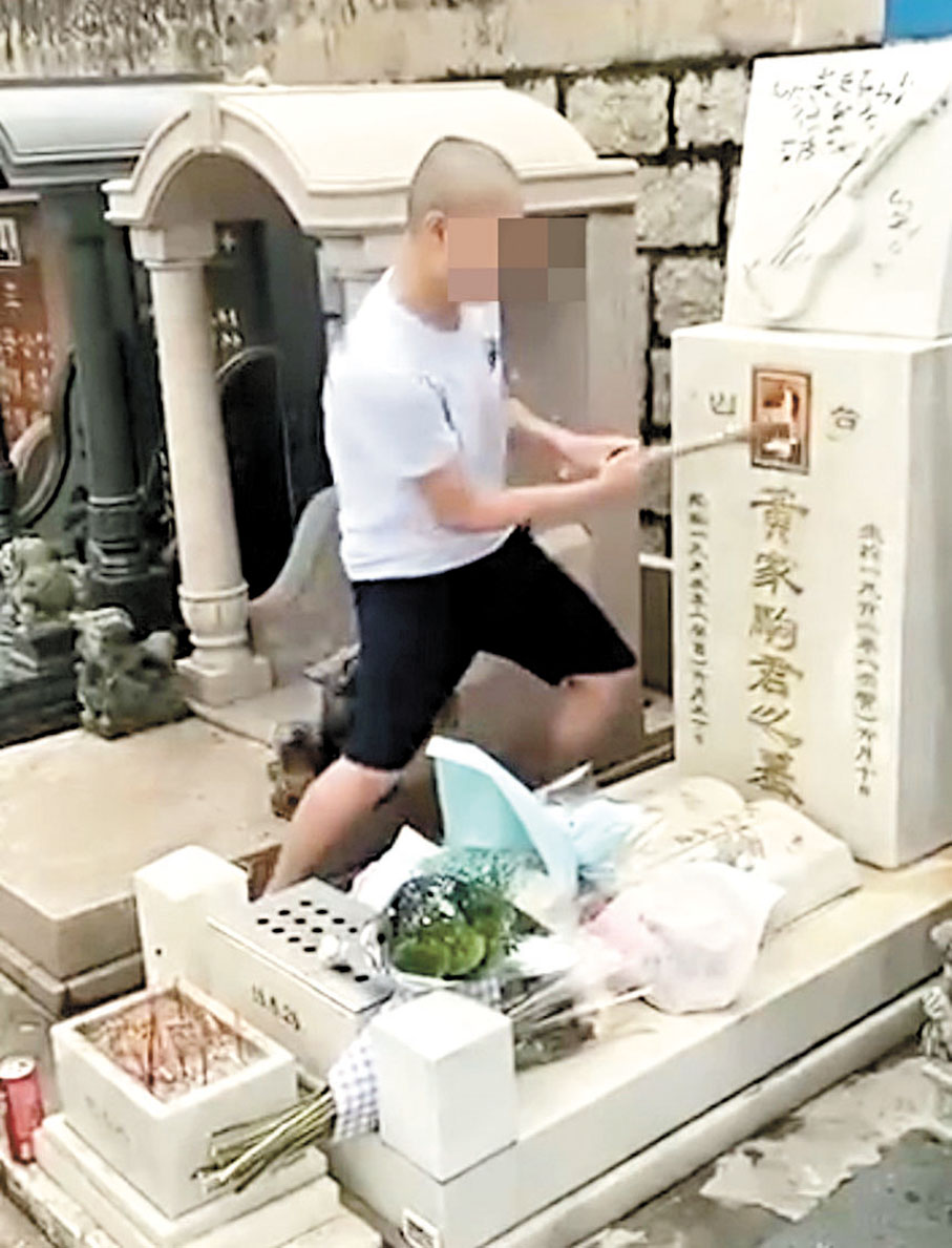 ◆案發當日其中一名被告以鎚仔扑毀墓碑上家駒的遺照。 資料圖片