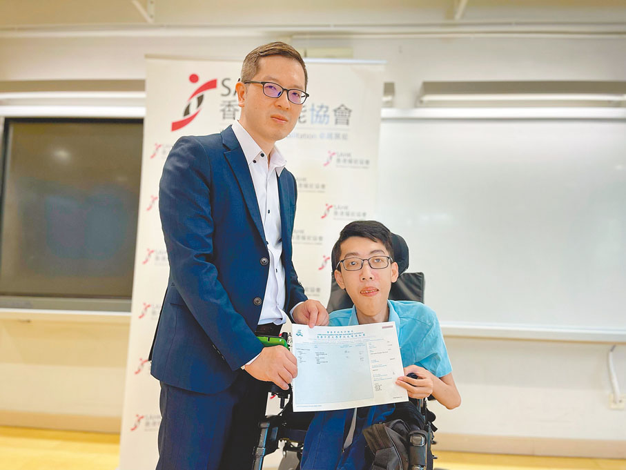 ◆林凱涵（右）今年再接再厲重考中文及英文科，由校長孫友民（左）派發成績單，並加以鼓勵。香港耀能協會圖片