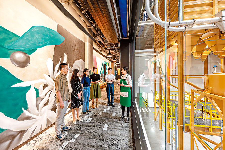 ◆產業園中，星巴克工作人員向參觀者介紹咖啡豆的烘焙過程。 香港文匯報浙江傳真