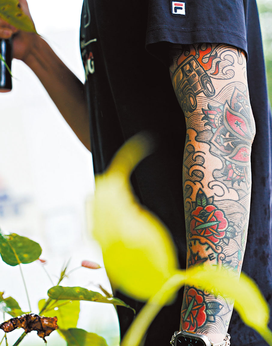 ◆何瑋桁左臂全臂紋上喜愛的事物，香港區徽、劍擊面罩、愛車等。香港文匯報記者葉詩敏 攝