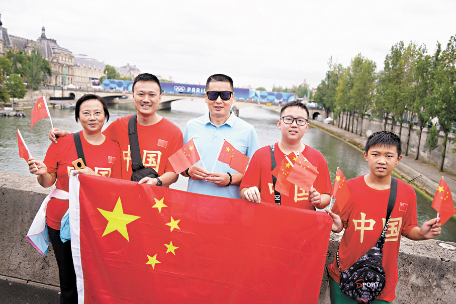 ◆塞納河畔，一家來自廣東順德的遊客，向文匯報記者展示他們為奧運健兒助威而準備的國旗。 大公文匯全媒體記者麥鈞傑 攝