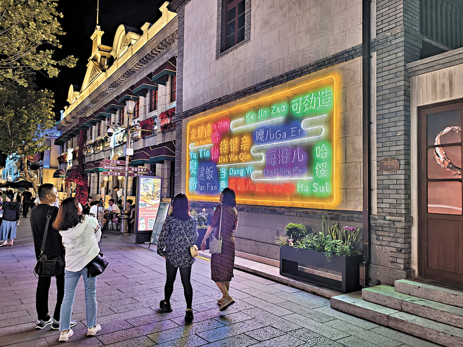 ◆路人駐足觀賞朝陽街的煙台方言燈牌。