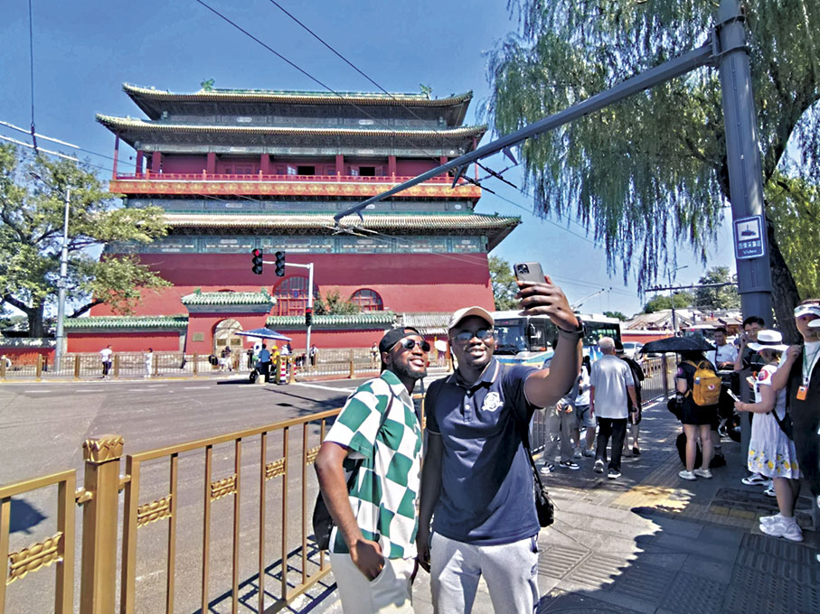 ◆來自加納的王成功（左）和朋友在北京中軸線上的鼓樓前留影。