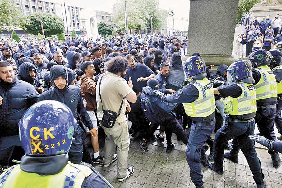 ◆博爾頓市警方分隔敵對雙方示威者。 路透社