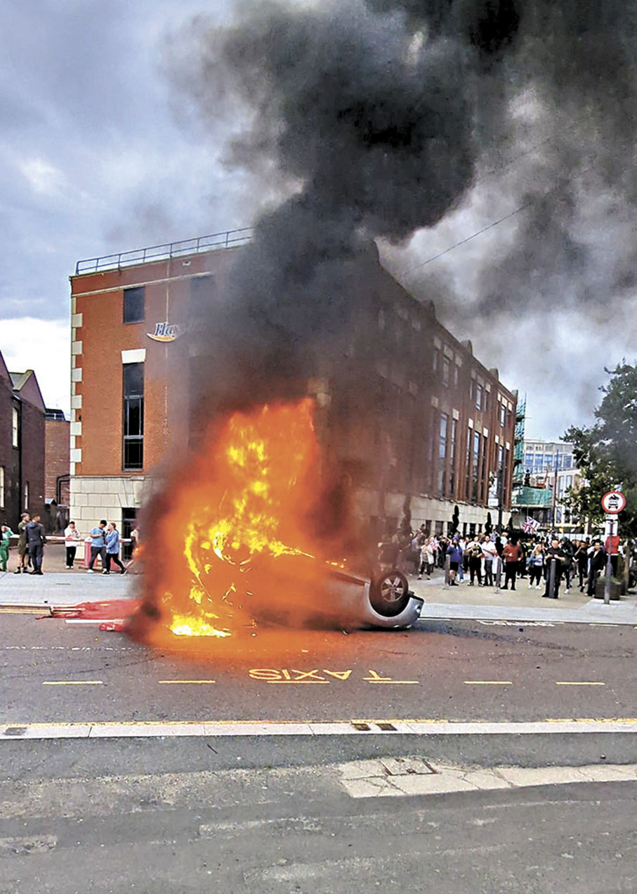 ◆桑德蘭一輛汽車被推翻縱火。 路透社