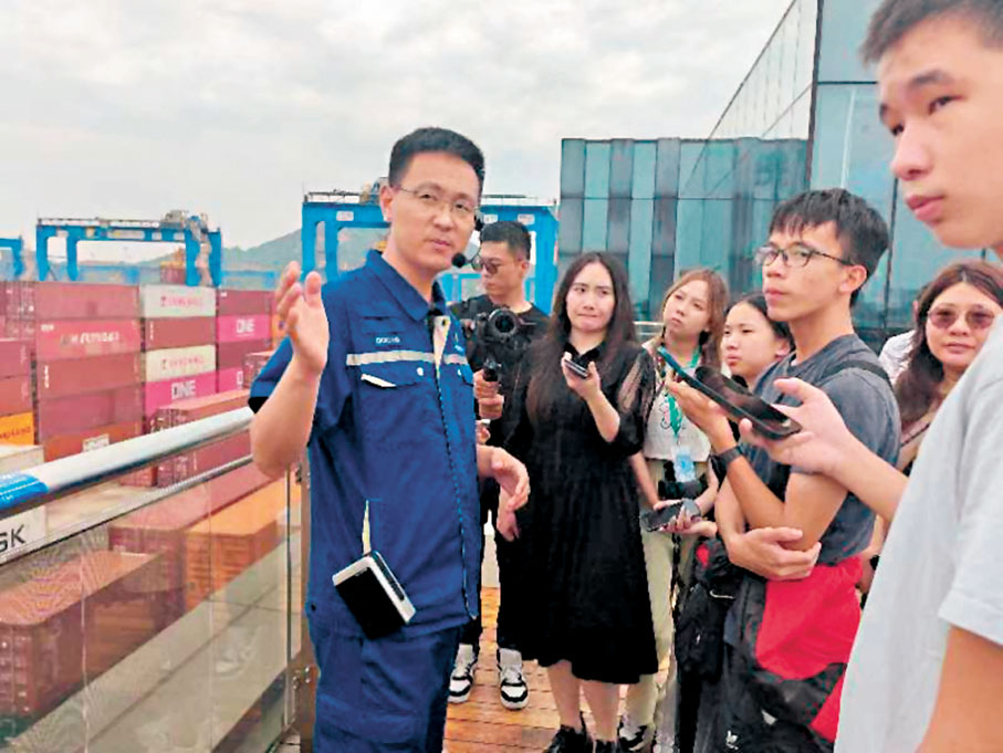 ◆學子在青島港全自動化碼頭採訪。 香港文匯報記者胡臥龍  攝