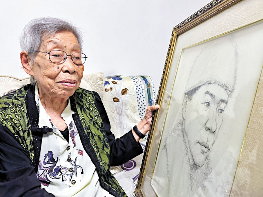 ◆桑桂芳捧着父親桑元慶的肖像接受香港文匯報記者專訪。香港文匯報記者于海江  攝