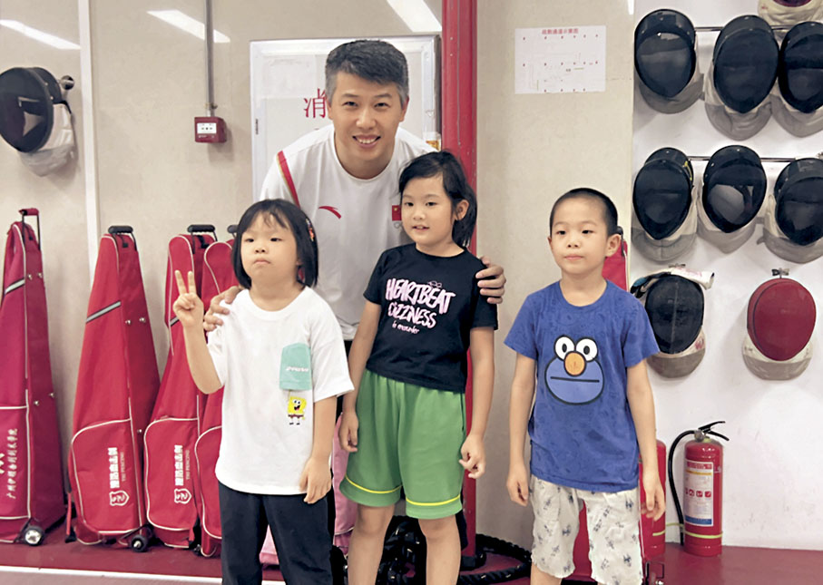 ◆擊劍世界冠軍朱俊和小學員合影。 香港文匯報記者敖敏輝 攝