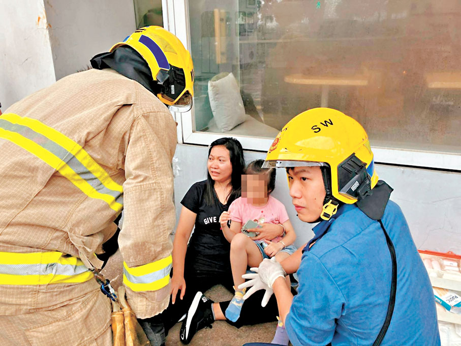 ◆輕傷女傭抱着受傷6歲女童坐在路邊，一臉驚恐。網上圖片