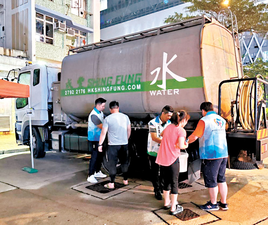 ◆關愛隊義工於供水車附近候命，協助居民領取食水。