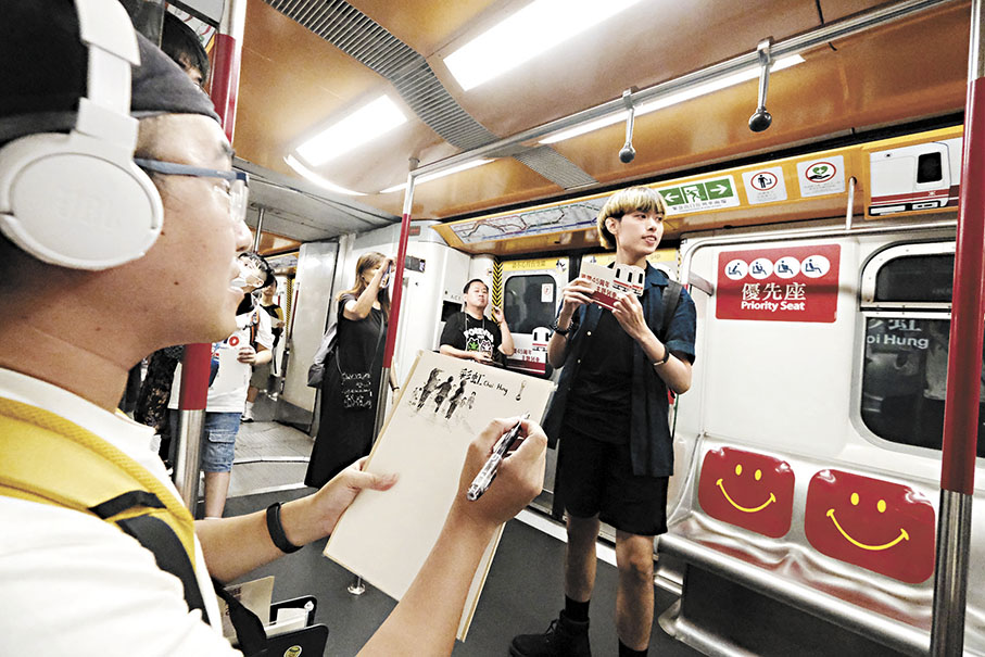 ◆陳先生在「白頭」列車內素描，記錄巿民搭乘列車的情況。 香港文匯報記者涂穴  攝