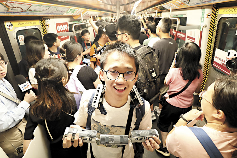 ◆鐵路迷帶同列車模型乘搭復刻版的「白頭」列車。 香港文匯報記者涂穴  攝