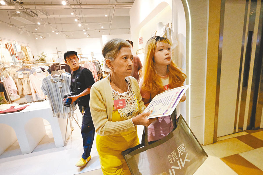 ◆參賽者梁小姐（黃衫）在職員陪同下前往購物。香港文匯報記者涂穴  攝