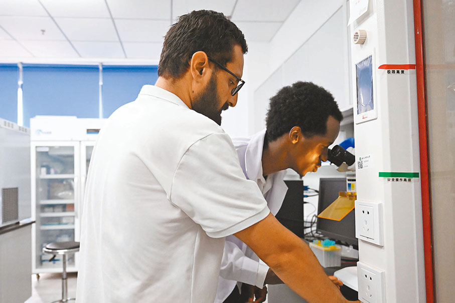 ◆在位於安徽省合肥市的安徽農業大學，盧旺達青年孔七（右）和同學在實驗室用顯微鏡觀察花粉樣本。新華社