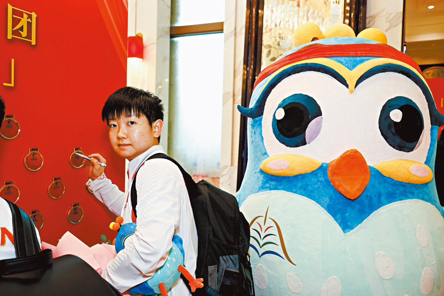 ◆孫穎莎昨日在澳門歡迎儀式現場設置的獎牌牆上簽名。 中通社