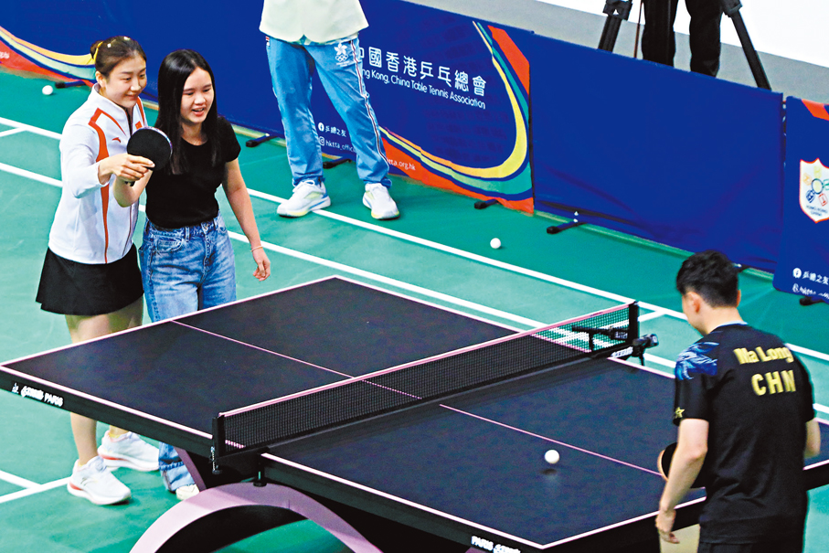 ◆陳夢（左一）手把手教現場觀眾與馬龍（右）對戰。香港文匯報記者北山彥  攝