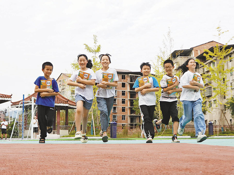 ◆新學期到來之際，各學校精心做好開學準備。圖為四川省達州市達川區罐子鎮中心小學學生領到新課本。  新華社