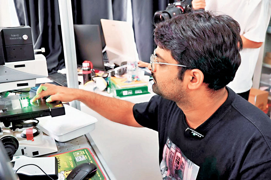 ◆中國豐富的資源和先進的設備讓阿巴斯感慨不已，有時，他在實驗室裏一待就是八個小時。圖為阿巴斯將樣品放在儀器中準備做實驗。香港文匯報實習記者鄭瀟雨 攝