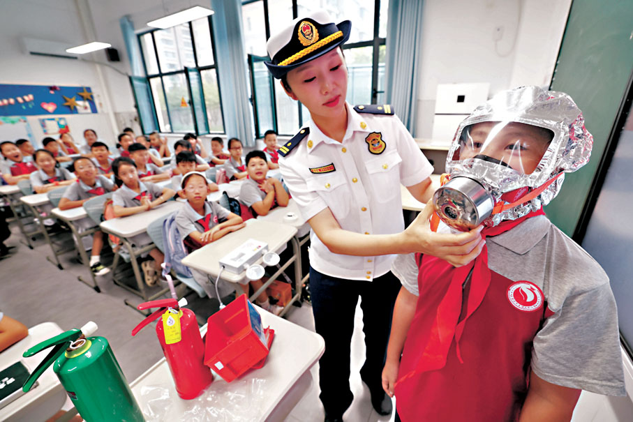 ◆ 以「可愛的中國」為主題的2024年《開學第一課》9月1日晚在央視等多個平台播出。圖為9月1日，在河北石家莊友誼大街小學開學第一課上，消防隊員為學生講解消防防護面具使用方法。 新華社