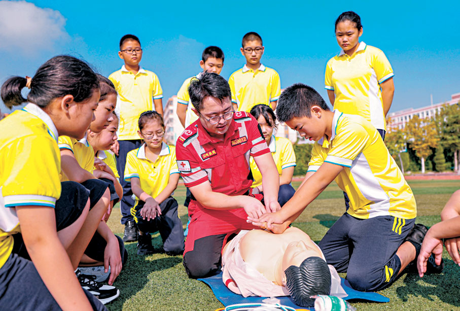 ◆ 8月31日，榮成市紅十字會志願者輔導學生進行心肺復甦操作。 新華社