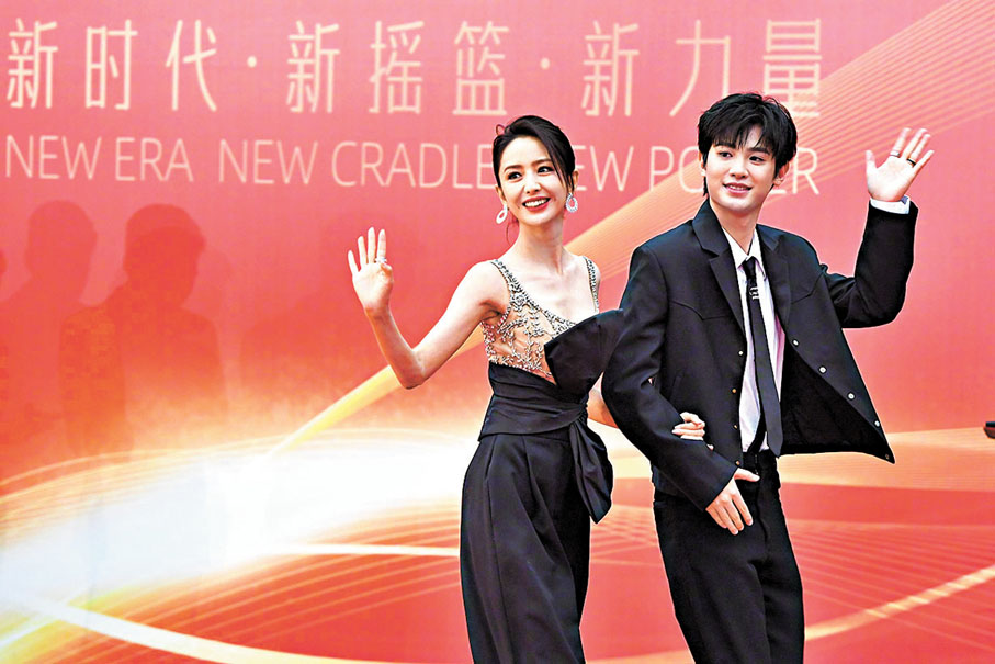 ◆佟麗婭與黃明昊向影迷揮手致意。新華社