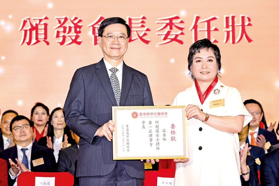 ◆ 李家超（左）頒發會長委任狀予何超蕸。