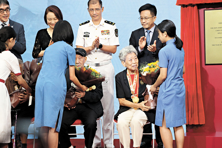 ◆一批中學生向出席活動的原東江縱隊港九獨立大隊的老戰士獻花。 香港文匯報記者黃艾力  攝